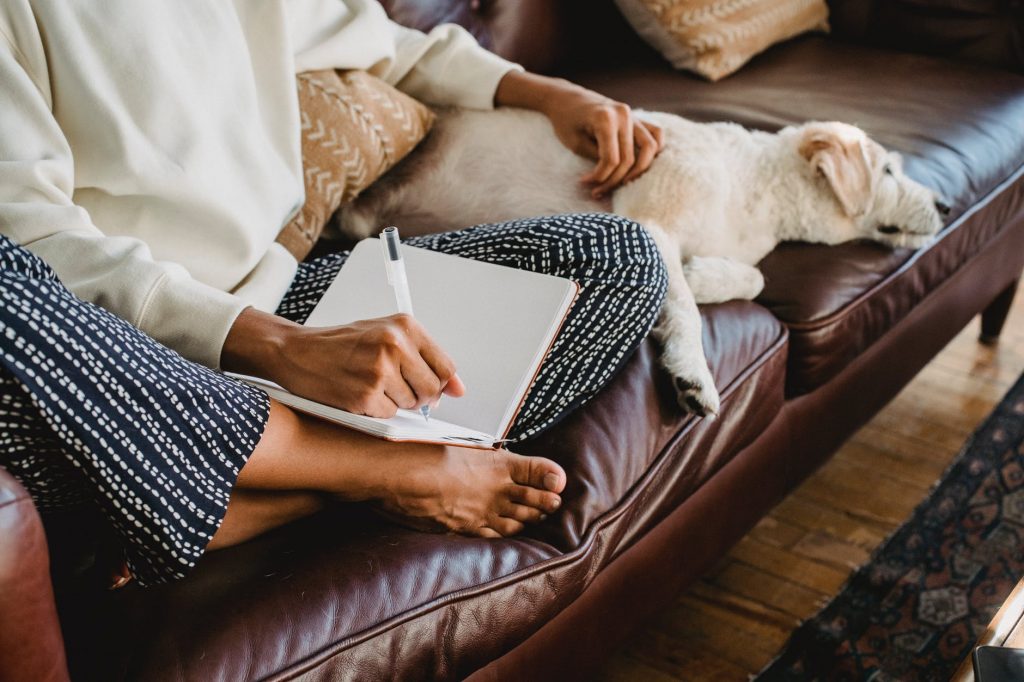 a person writing beside a sleeping dog
